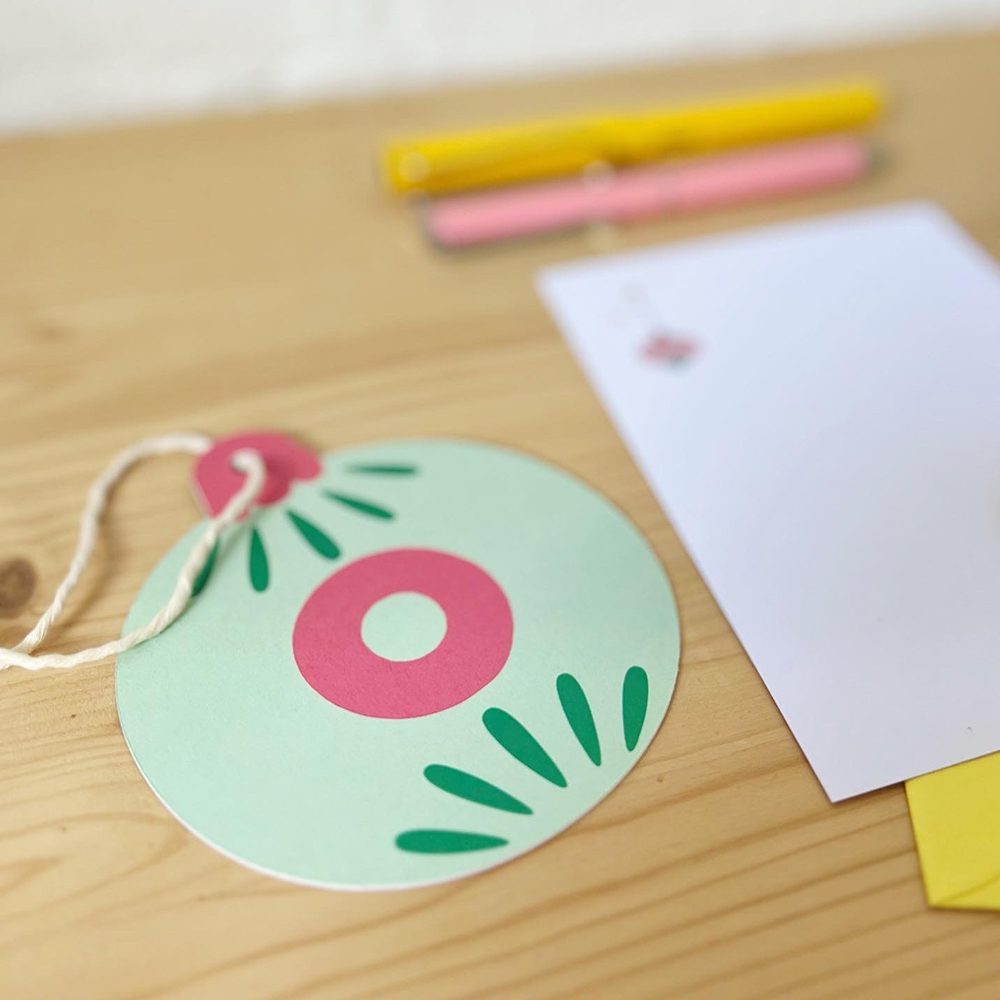 Alfabet kerstbal kaart letter O op bureau met blanco kaart en envelop en twee pennen
