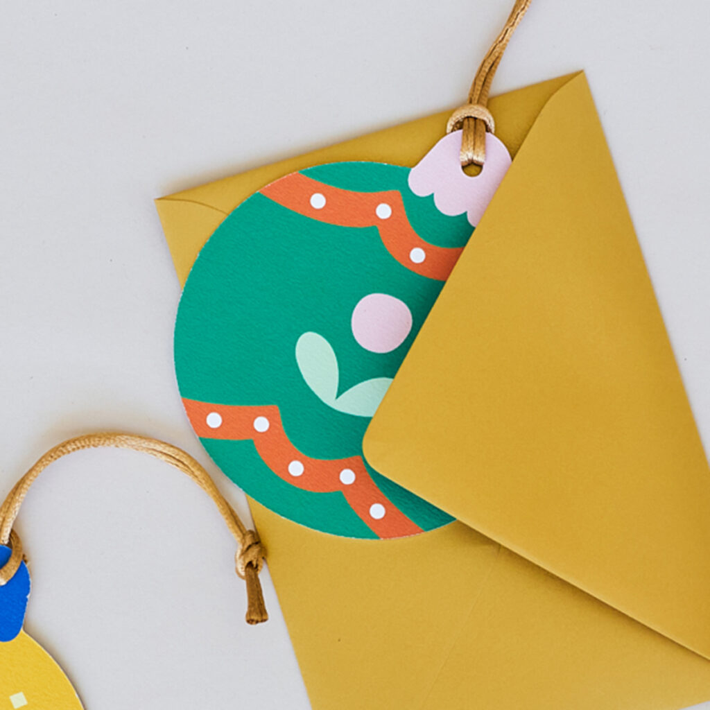 Stevige papieren kerstbal met een heldere en vrolijke illustratie van een winterbloem. Gemaakt van duurzaam materiaal, ideaal voor een milieuvriendelijke kerstversiering. De kerstbal heeft een levendige uitstraling, perfect voor in de kerstboom of als kleurrijke decoratie.
